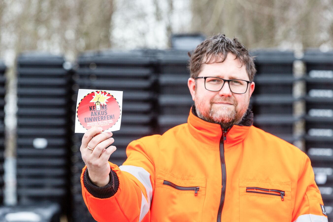 Stephan Wilmer zeigt die roten Warnaufkleber für die Mülltonnen, Foto: maxpress/srk