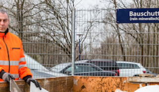 SAS-Mitarbeiter Andreas Peters zeigt, was alles in den Container für den mineralischen Bauschutt gebracht werden darf, Foto: maxpress/srk